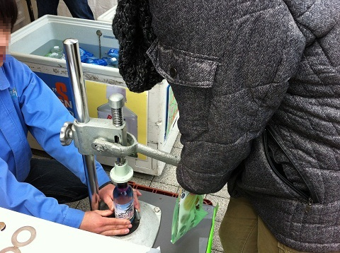 打栓機に体重をかけて栓をしているところ